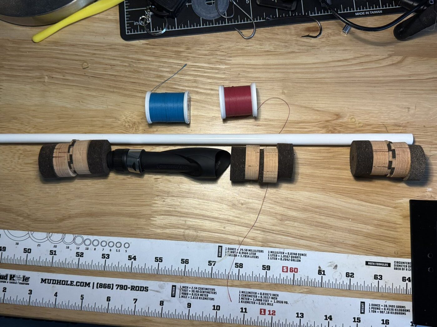 Rod blank, grip components, reel seat, and thread colors arranged while planning a custom fishing rod