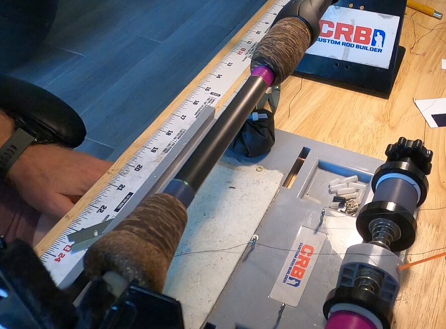 Two thread-color options temporarily wrapped onto a fishing rod blank for a client to compare